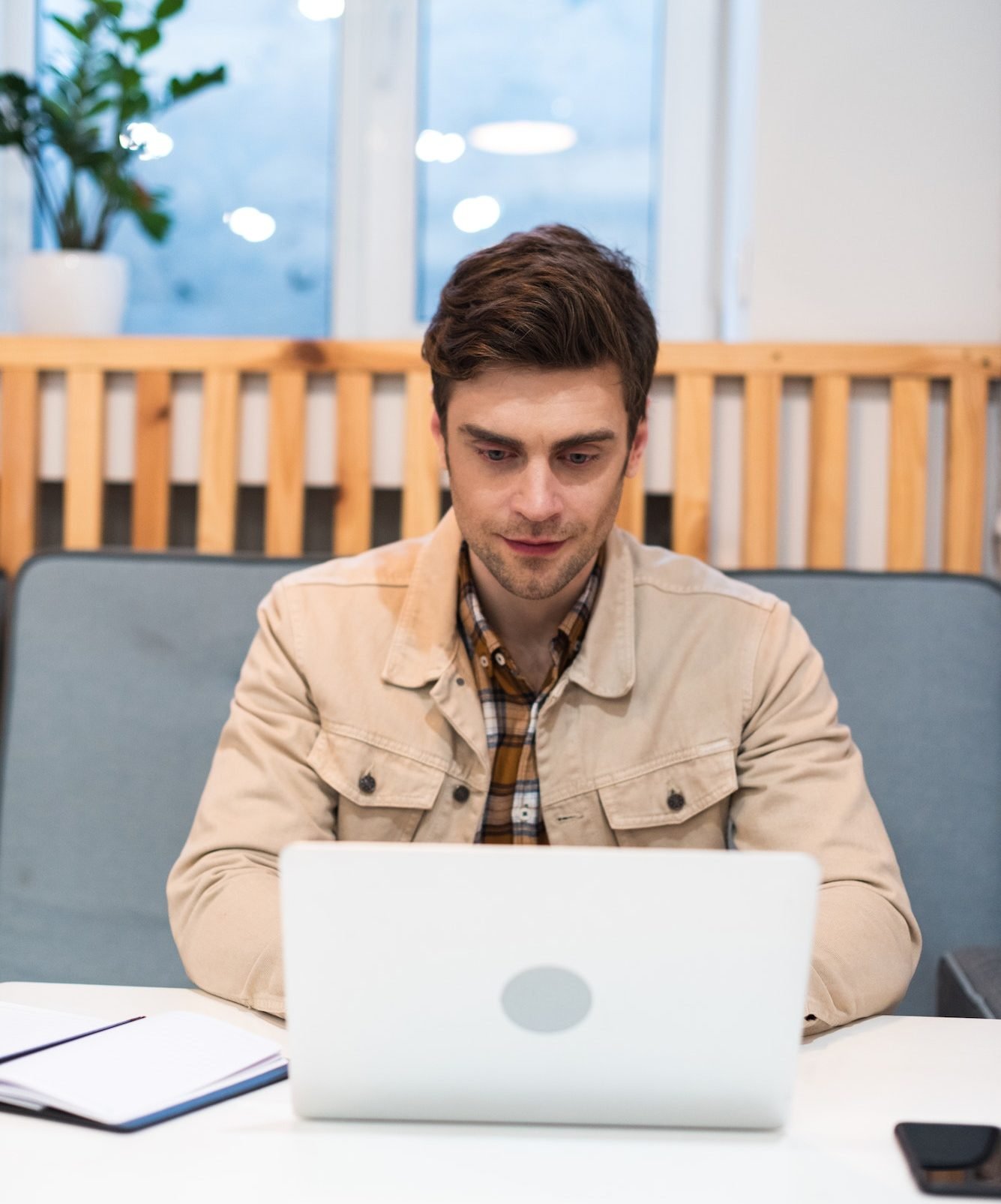 concentrated freelancer working with laptop at table in cafe e1687057130512